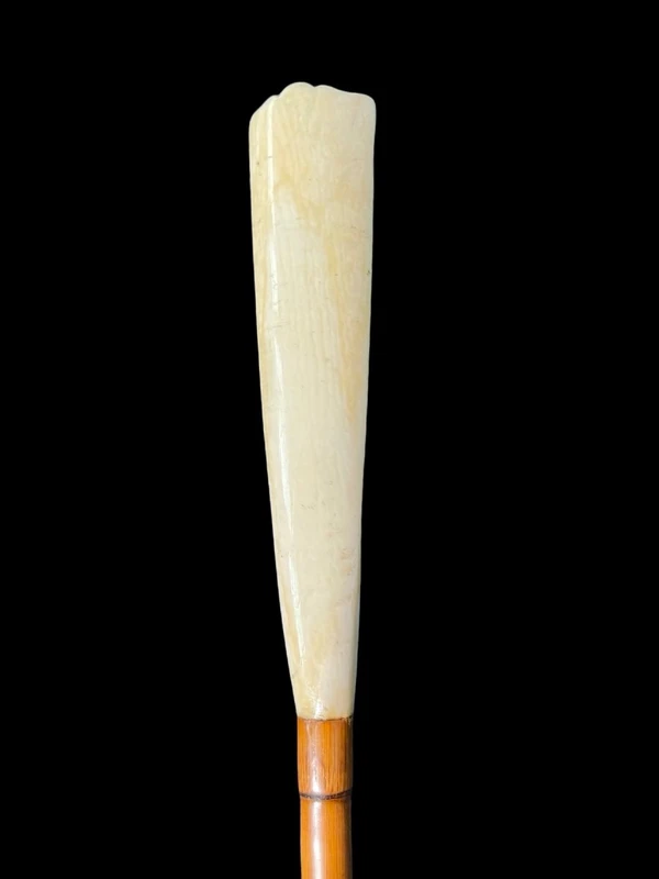 A walking stick with a "plume" knob featuring a high-relief figure of a child playing with a cat.