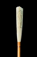 A walking stick with a "plume" knob featuring a high-relief figure of a child playing with a cat.