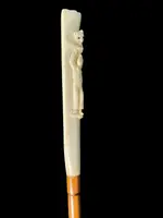 A walking stick with a "plume" knob featuring a high-relief figure of a child playing with a cat.