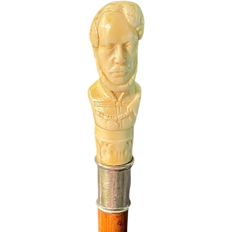 Cane with an ivory knob depicting a male bust. The shaft is made of rattan.
