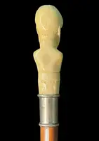 Cane with an ivory knob depicting a male bust. The shaft is made of rattan.