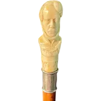 Cane with an ivory knob depicting a male bust. The shaft is made of rattan.