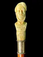 Cane with an ivory knob depicting a male bust. The shaft is made of rattan.
