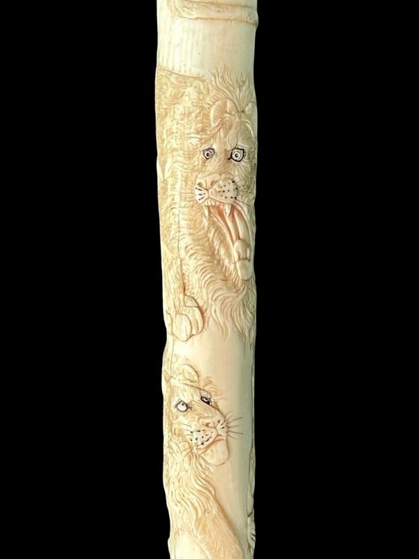 An evening cane with an ivory “plume” knob engraved with lions in bas-relief.