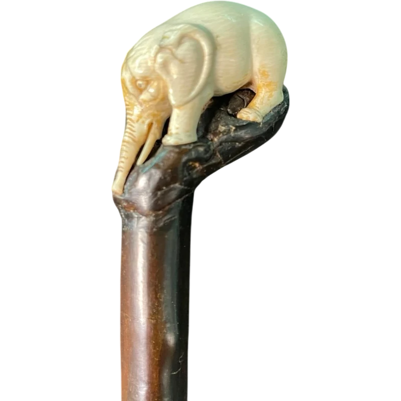 A walking stick with a partially ivory pommel featuring an elephant figure in high relief.