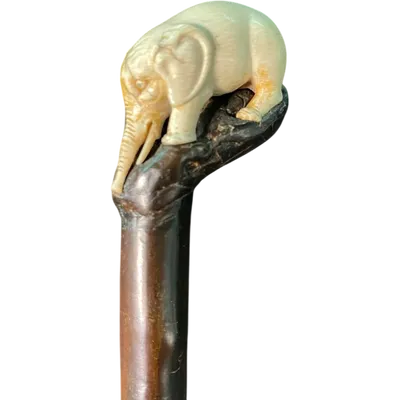 A walking stick with a partially ivory pommel featuring an elephant figure in high relief.