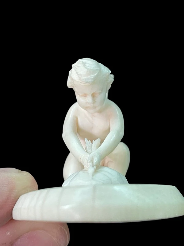 Petite sculpture en ivoire représentant Cupidon en train d'aiguiser