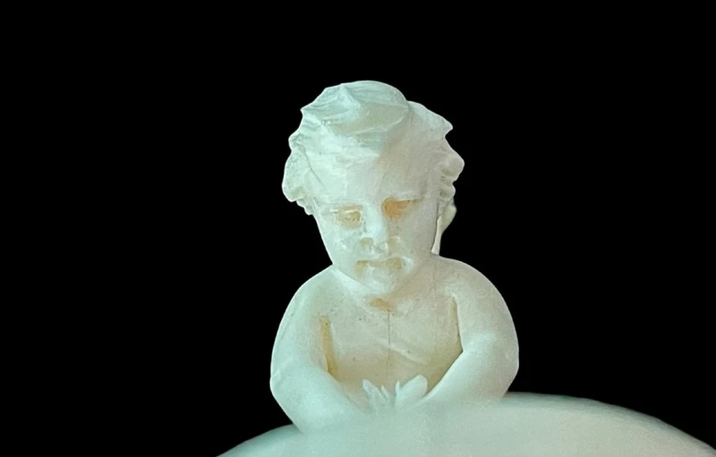Petite sculpture en ivoire représentant Cupidon en train d'aiguiser