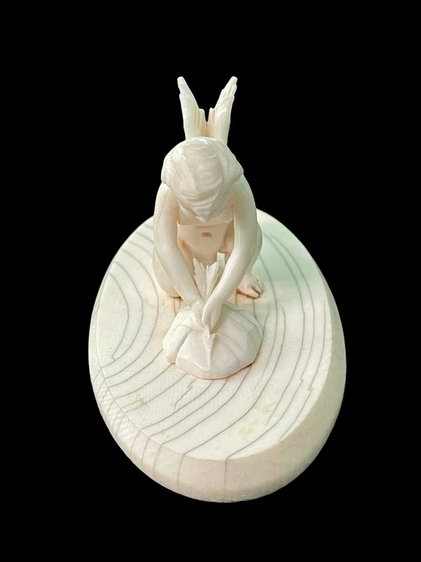 Petite sculpture en ivoire représentant Cupidon en train d'aiguiser