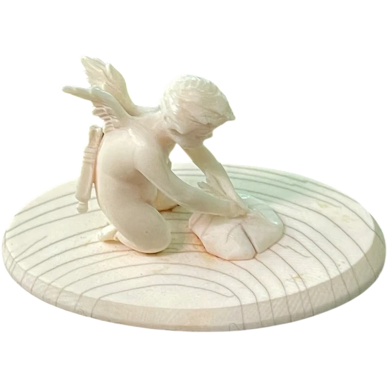 Petite sculpture en ivoire représentant Cupidon en train d'aiguiser