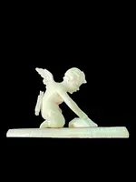 Petite sculpture en ivoire représentant Cupidon en train d'aiguiser