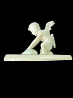 Petite sculpture en ivoire représentant Cupidon en train d'aiguiser