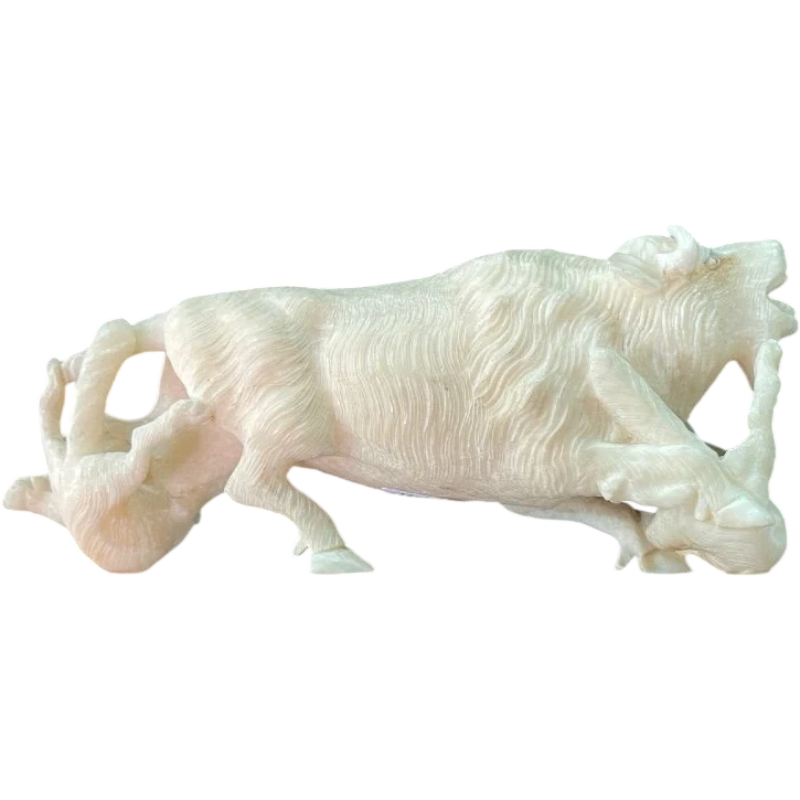 Scultura in avorio raffigurante un bisonte attaccato da due lupi.