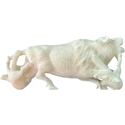 An ivory sculpture depicting a bison being attacked by two wolves.