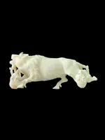 Scultura in avorio raffigurante un bisonte attaccato da due lupi.