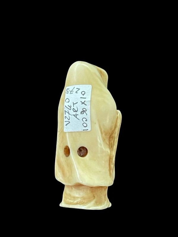Ivory netsuke depicting a male figure wearing a cloak. Japan.
