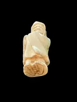 Ivory netsuke depicting a male figure wearing a cloak. Japan.