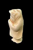 Ivory netsuke depicting a male figure wearing a cloak. Japan.