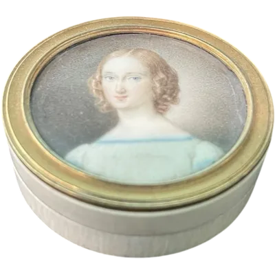A small ivory box with a painted miniature depicting a female figure.