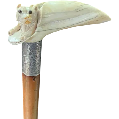 A walking stick with an ivory handle depicting a hidden dog.
