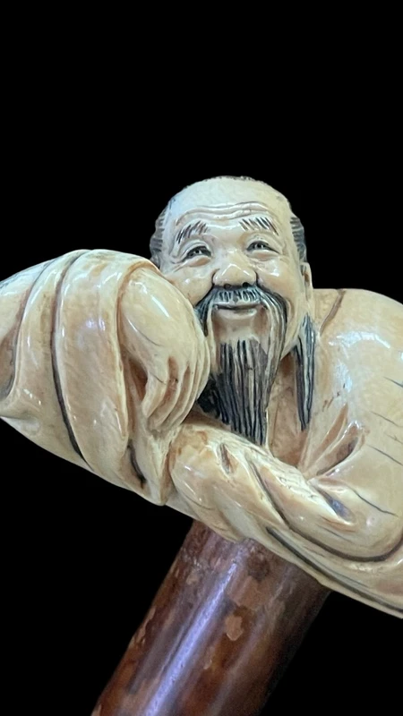 Bâton avec un manche en ivoire représentant un Japonais allongé.