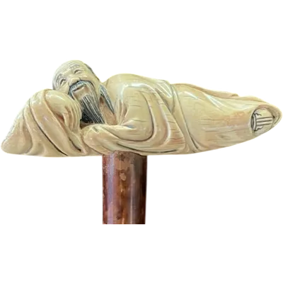 A walking stick with an ivory handle depicting a reclining Japanese man.