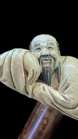 Bâton avec un manche en ivoire représentant un Japonais allongé.