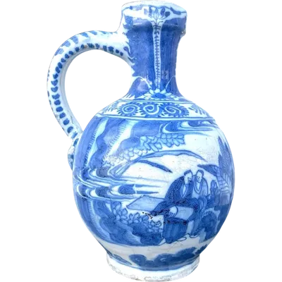 A monochrome blue majolica pitcher featuring a pair of figures