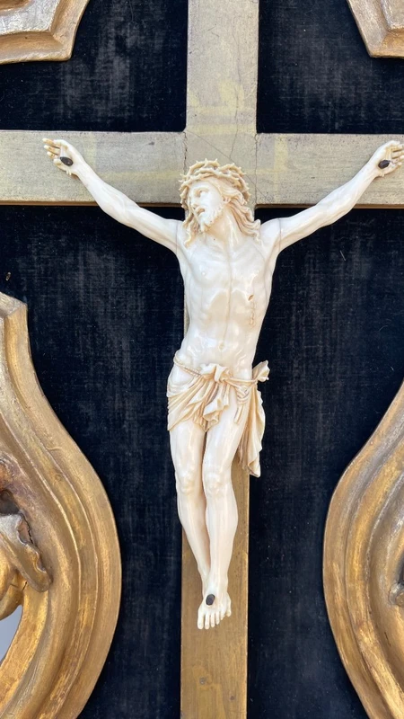 Christ en ivoire, dans un cadre en forme de cartouche en bois sculpté et doré à la feuille.