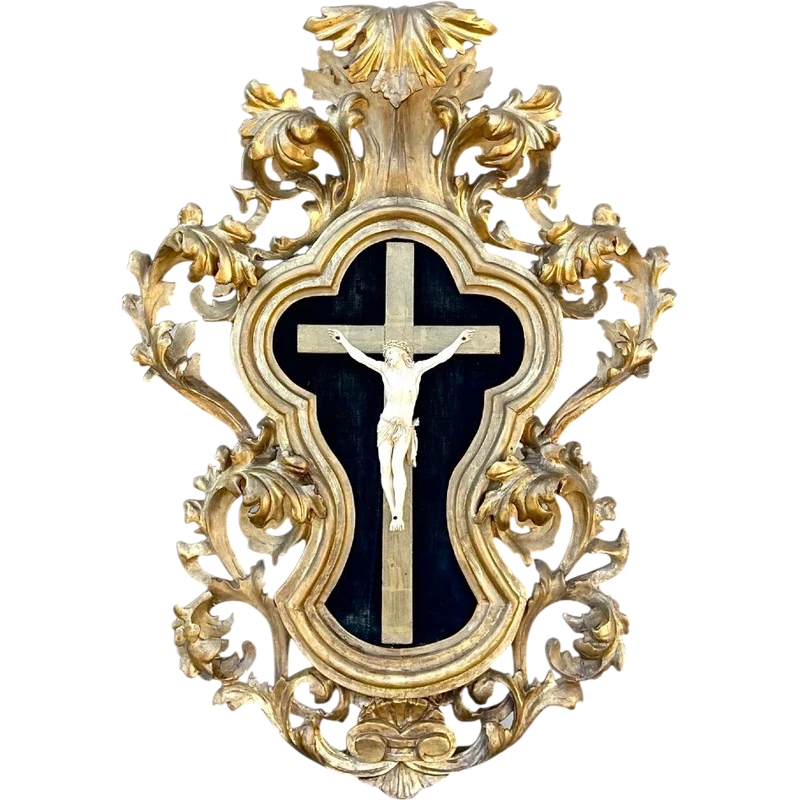 Christ en ivoire, dans un cadre en forme de cartouche en bois sculpté et doré à la feuille.