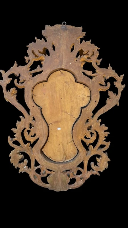 Christ en ivoire, dans un cadre en forme de cartouche en bois sculpté et doré à la feuille.