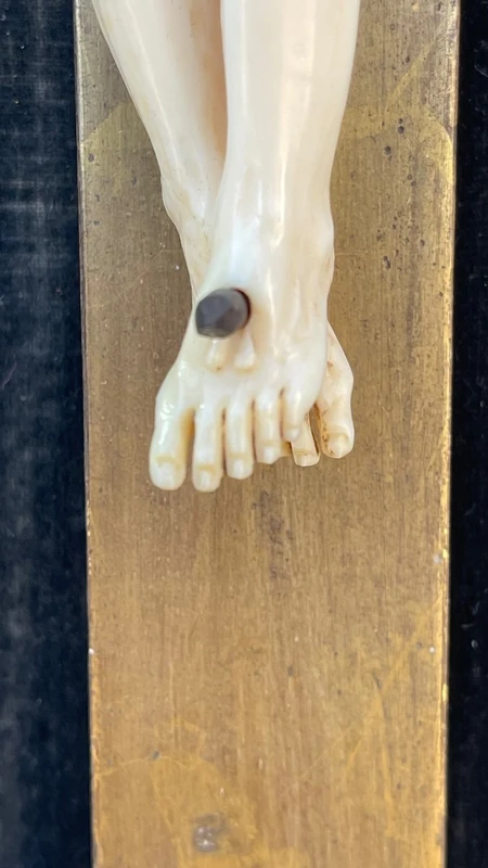 Christ en ivoire, dans un cadre en forme de cartouche en bois sculpté et doré à la feuille.