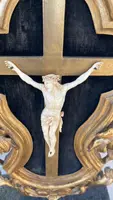 Christ en ivoire, dans un cadre en forme de cartouche en bois sculpté et doré à la feuille.