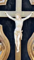 Christ en ivoire, dans un cadre en forme de cartouche en bois sculpté et doré à la feuille.