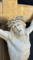 Christ en ivoire, dans un cadre en forme de cartouche en bois sculpté et doré à la feuille.