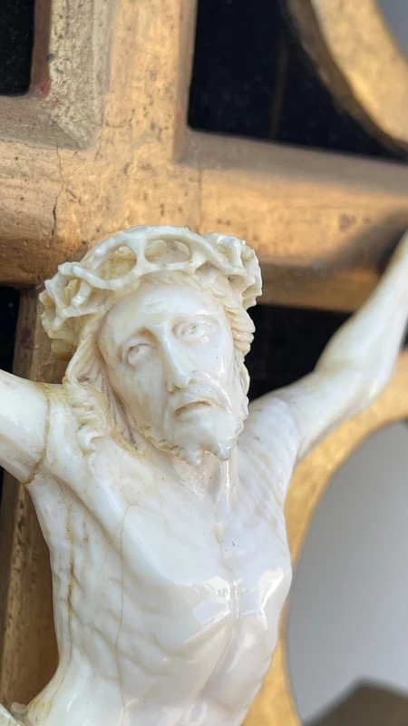 Christ en ivoire sur un cadre-bénitier en bois sculpté et doré à la feuille