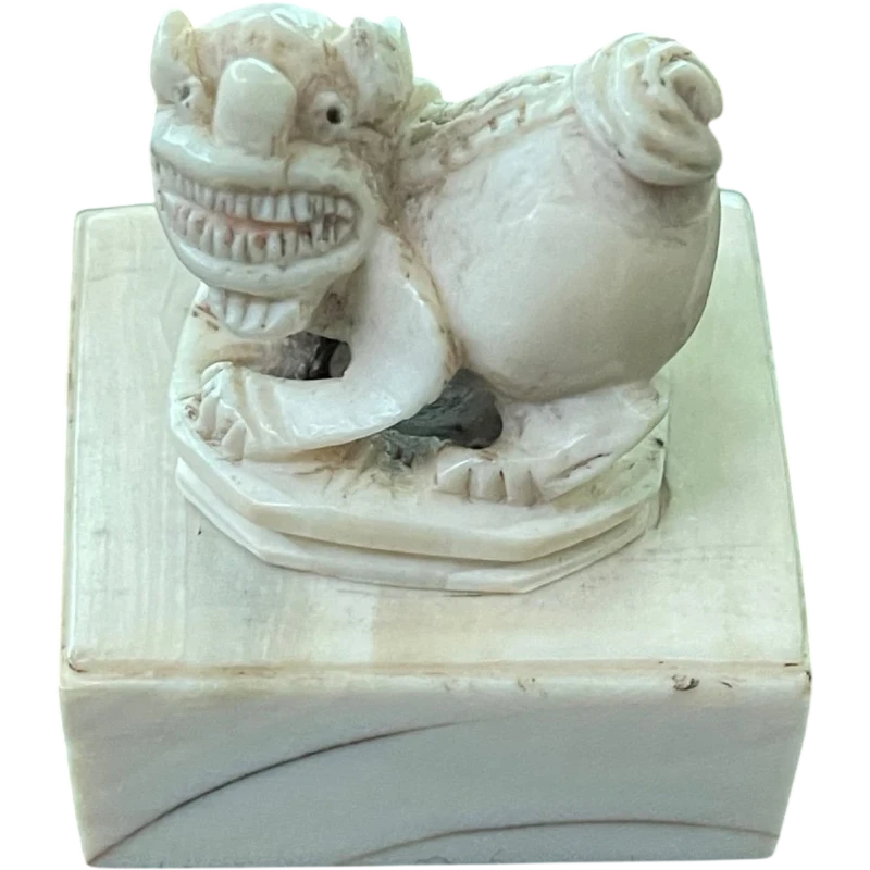 Sigillo in avorio con presa a forma di animale grottesco.