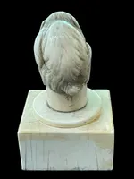Petite sculpture en ivoire (poignée de canne) posée sur un socle carré et représentant un singe.