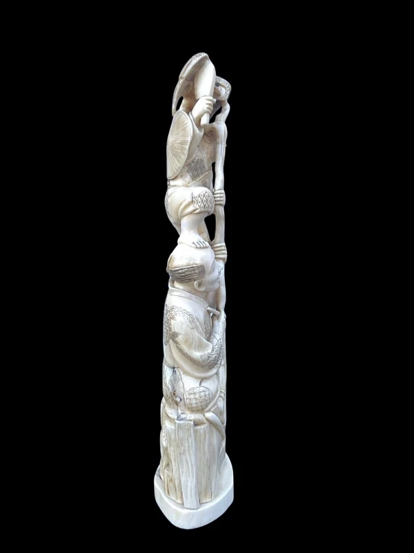 Sculpture en ivoire de type « okimono » représentant deux personnages masculins accompagnés d'un aigle.