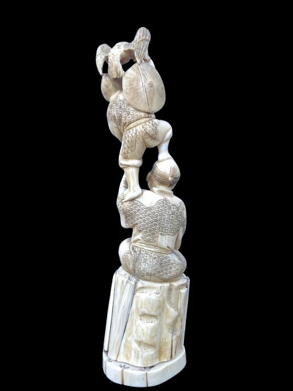 Sculpture en ivoire de type « okimono » représentant deux personnages masculins accompagnés d'un aigle.