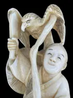 Sculpture en ivoire de type « okimono » représentant deux personnages masculins accompagnés d'un aigle.