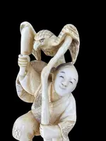 Sculpture en ivoire de type « okimono » représentant deux personnages masculins accompagnés d'un aigle.