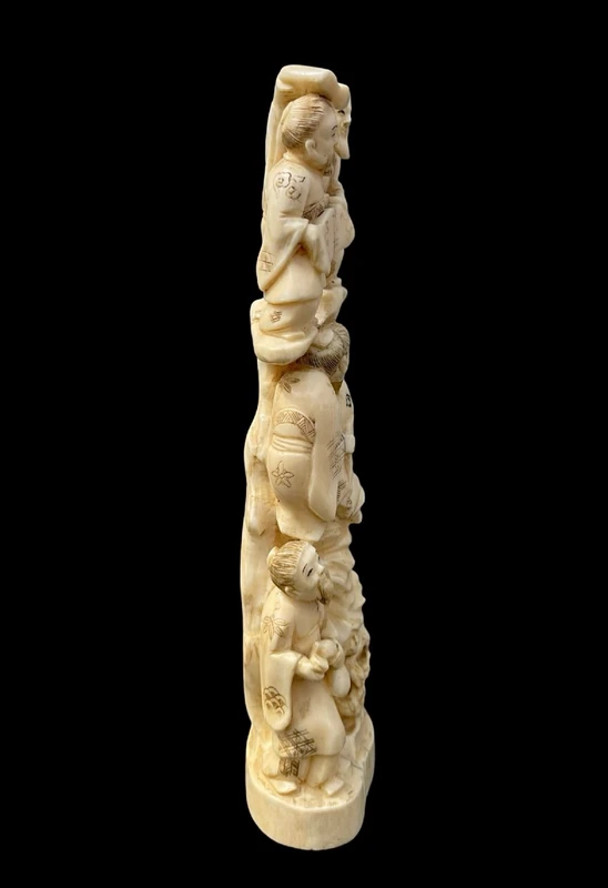 Scultura okimono in avorio con personaggi e pesce carpa.
