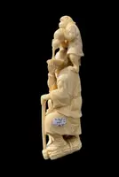 Sculpture okimono en ivoire représentant un personnage masculin avec un enfant et un singe.