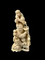 Sculpture okimono en ivoire représentant un personnage masculin avec un enfant et un singe.