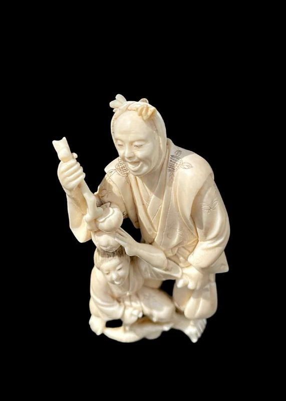 Scultura okimono in avorio con personaggio maschile e fanciullo.