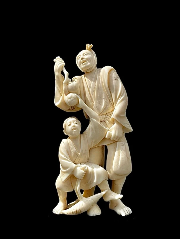 Scultura okimono in avorio con personaggio maschile e fanciullo.