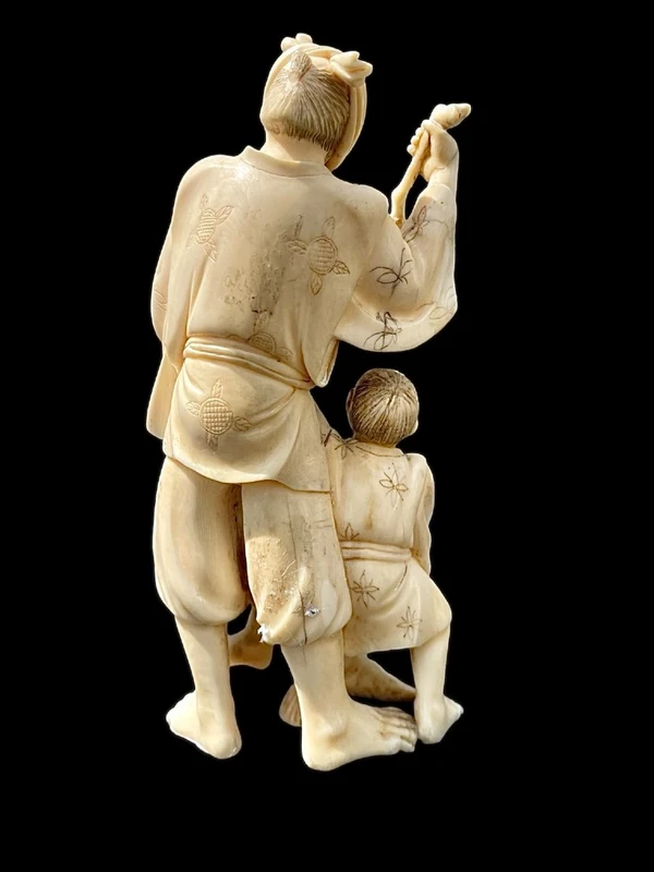 Scultura okimono in avorio con personaggio maschile e fanciullo.
