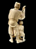 Scultura okimono in avorio con personaggio maschile e fanciullo.