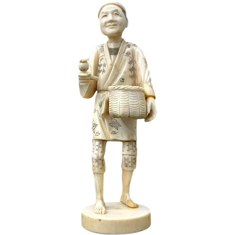 Sculpture okimono en ivoire représentant un personnage masculin portant un panier.